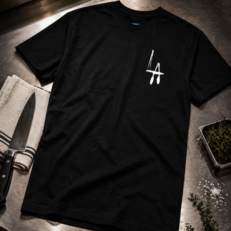 Black t-shirt with a logo on a metal prep table