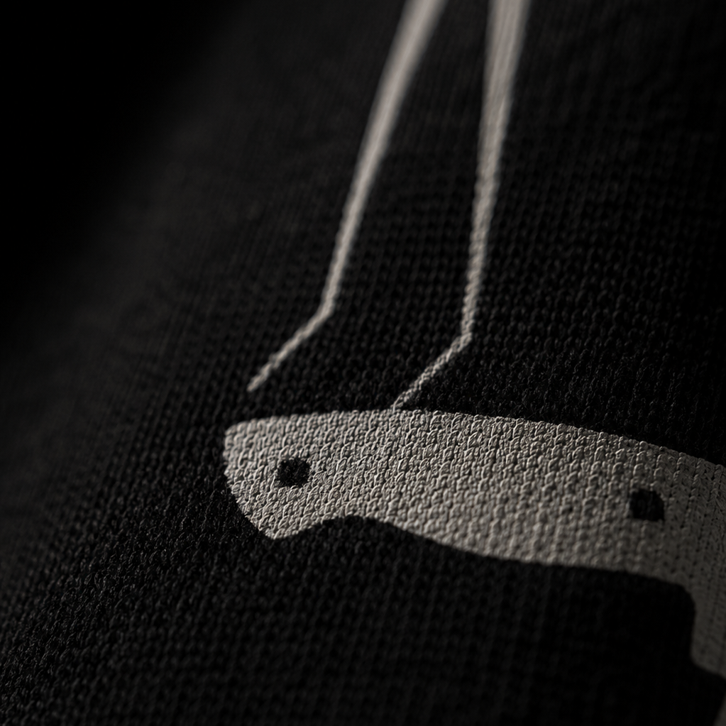 Close-up of a black sweater with a white logo on a dark background