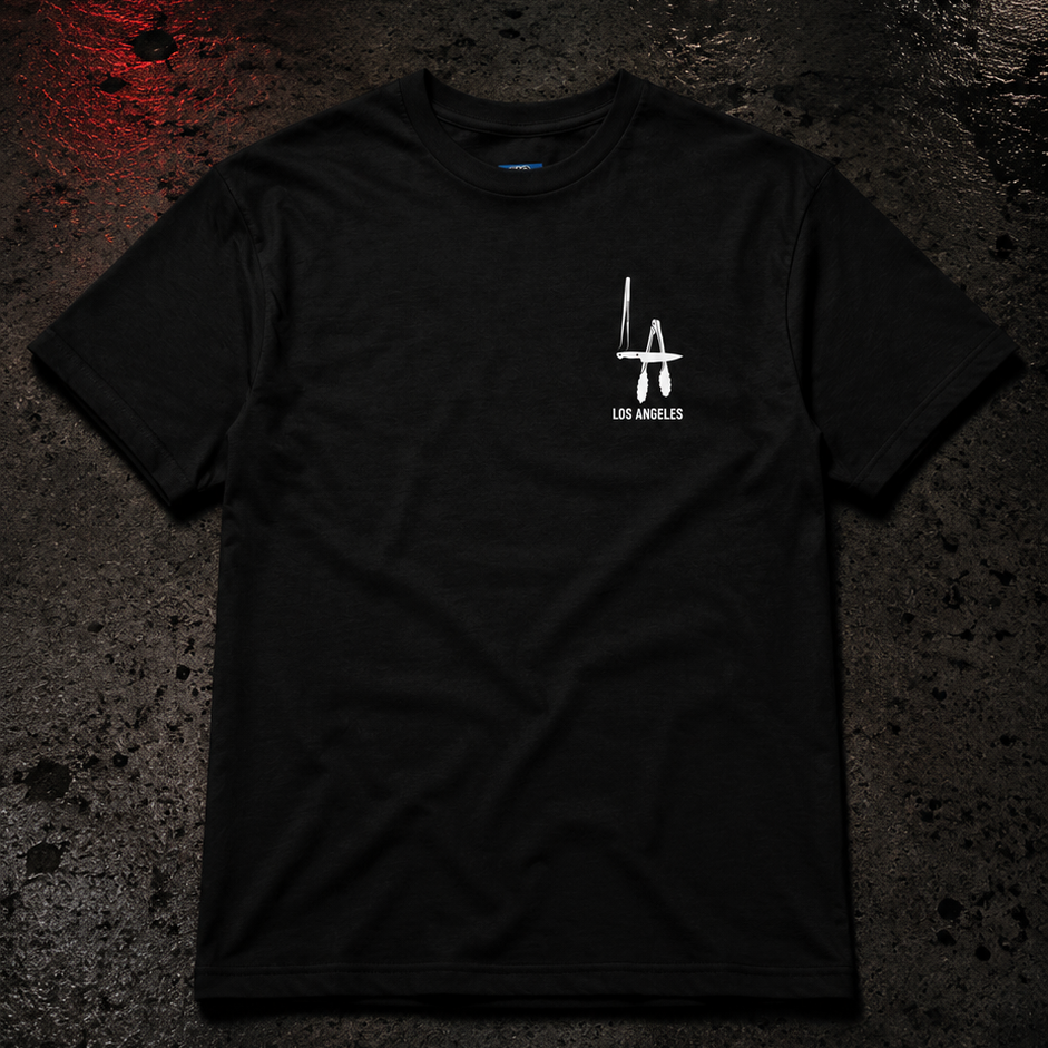 Black t-shirt with a logo on a dark, wet street at night